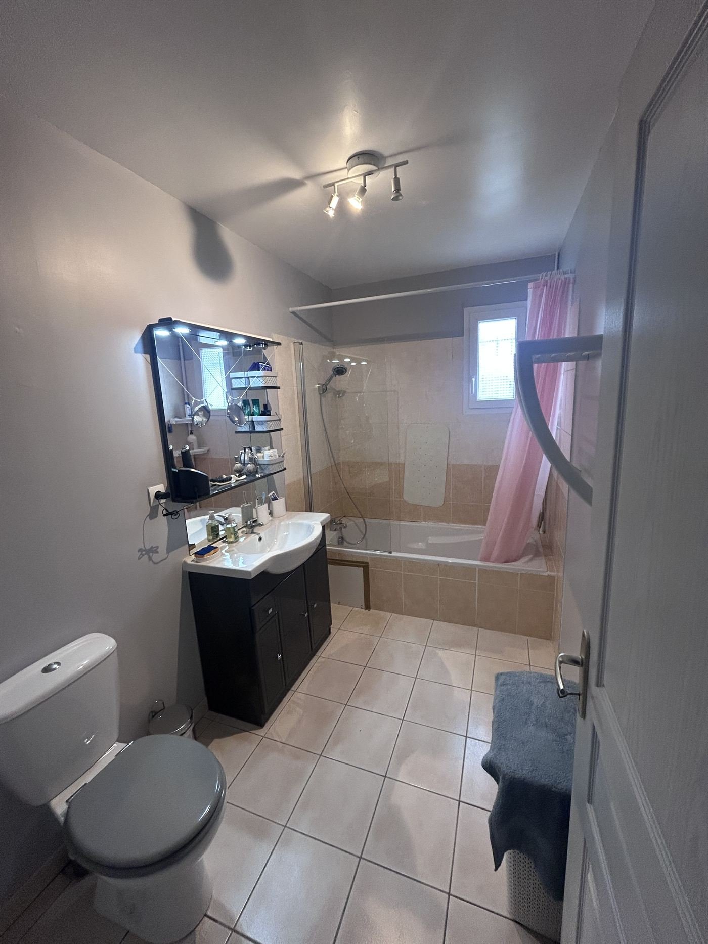 Salle de bain avant travaux : baignoire haute avec rideau, aucun point d'appui, meuble encombrant